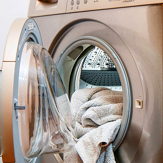 Geöffnete Waschmaschine mit Wäsche in der Trommel