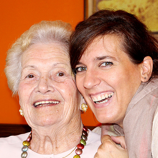 Seniorin und Pflegerin lachen