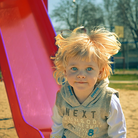 Kind vor einer Rutsche auf einem Spielplatz