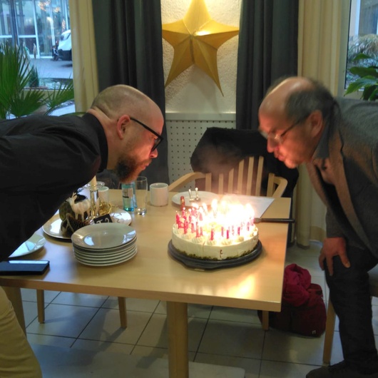 Rolf Müßig (ehemaliger Vorstand) bläst die Geburtstagskerzen aus beim 40-jährigen Jubiläum der Arche
