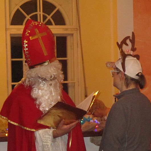 Der Nikolaus trägt einem Bewohner des Luisenhofs ein Gedicht vor.