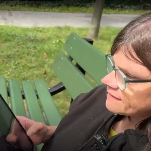 Die Bewohnerin ist mit ihrem Tablett zu sehen.