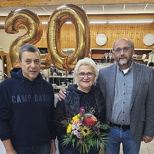 Familie Winkler und Rolf Müßig vor einem Zahlenballon.
