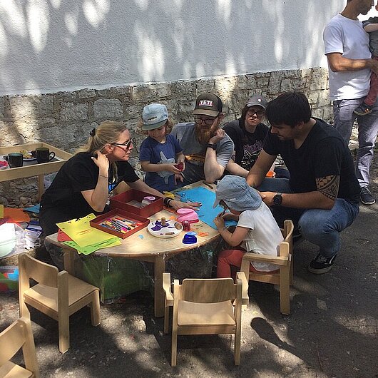 Kinder sitzen an einem Tisch und malen