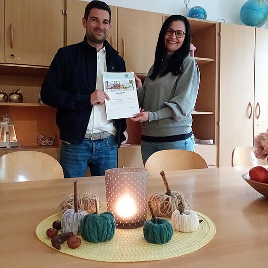 Links steht Herr Georgi, rechts Regionalleitung Frau Günther-Schmidt. Sie halten gemeinsam einen Spendenscheck hoch. 