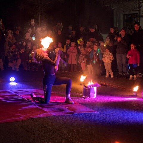 Ein Feuerspucker in Aktion vor einer Zuschauermenge