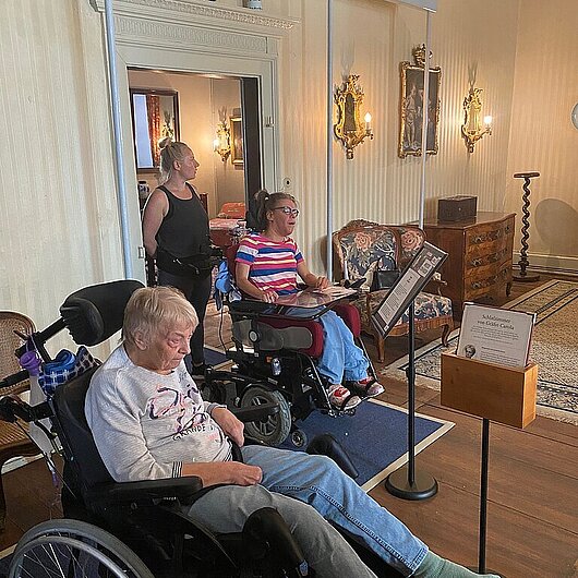 2 Menschen im Rollstuhl in einem Schloss