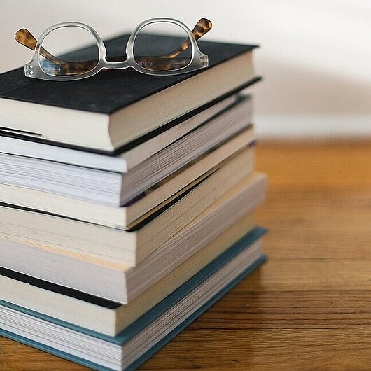 Ein Bücherstapel mit Lesebrille (Foto: Kari Shea // pixabay)
