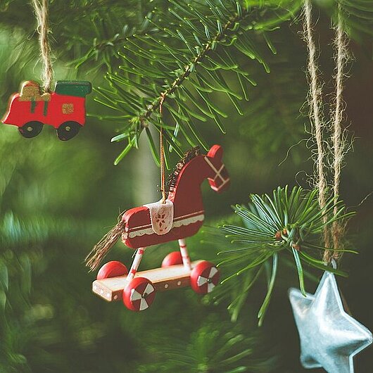 Detaillaufnahme von Weihnachtsschmuck an einem Tannenzweig; Foto Markus Spiske/unsplash