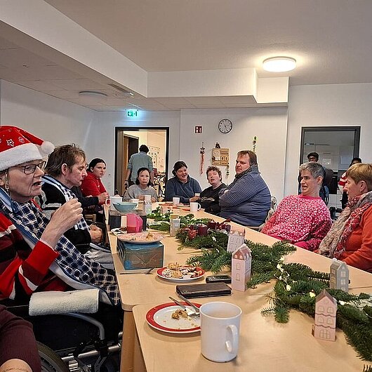 Auf dem Bild sind unsere Bewohner am Weihnachtlich geschmückten Tisch zu sehen